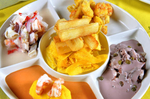 Foto de piqueo marino con chifles, yuquitas fritas y salsas gourmet.