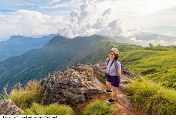 Chica turista disfrutando la actividad de hiking en la naturaleza
