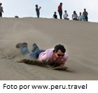 Practicando sandboarding en el desierto de Huacachina en Ica, Perú